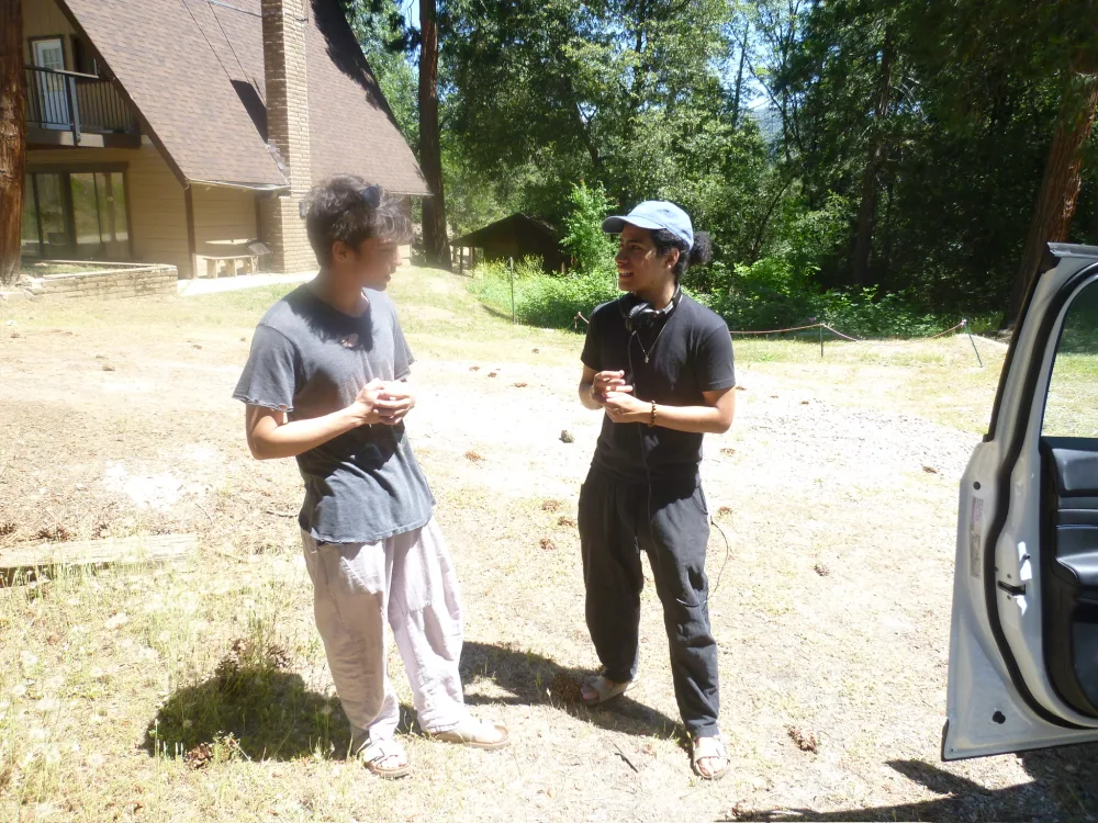 Two people talking outside a cabin